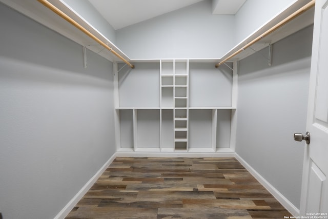 spacious closet featuring lofted ceiling and dark hardwood / wood-style floors