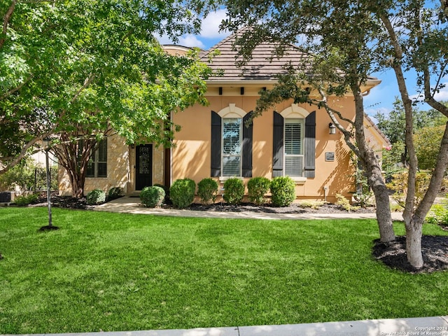 mediterranean / spanish house featuring a front yard