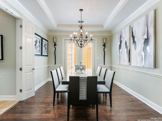 dining space featuring dark hardwood / wood-style flooring, a raised ceiling, and a notable chandelier