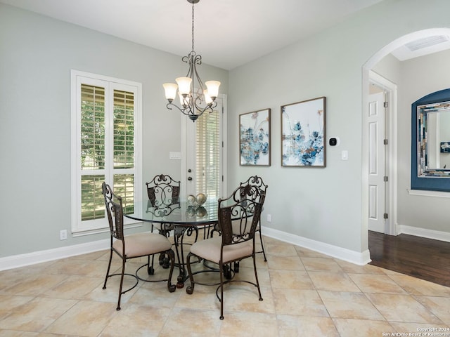 tiled dining space with an inviting chandelier