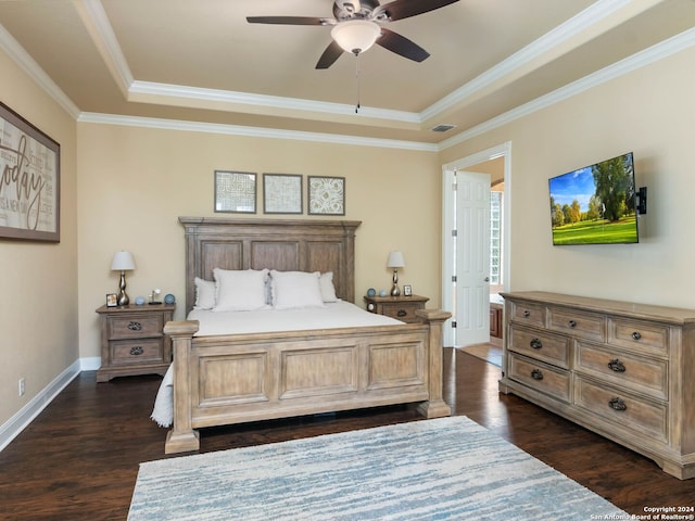 bedroom featuring dark wood-type flooring, ceiling fan, ornamental molding, and a tray ceiling