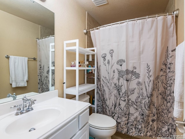 bathroom with vanity, toilet, a shower with curtain, and a textured ceiling