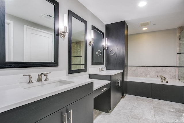 bathroom featuring two vanities, visible vents, a sink, and a garden tub