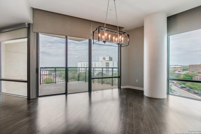 unfurnished living room featuring plenty of natural light and dark hardwood / wood-style floors