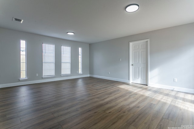 spare room with a wealth of natural light and dark hardwood / wood-style flooring