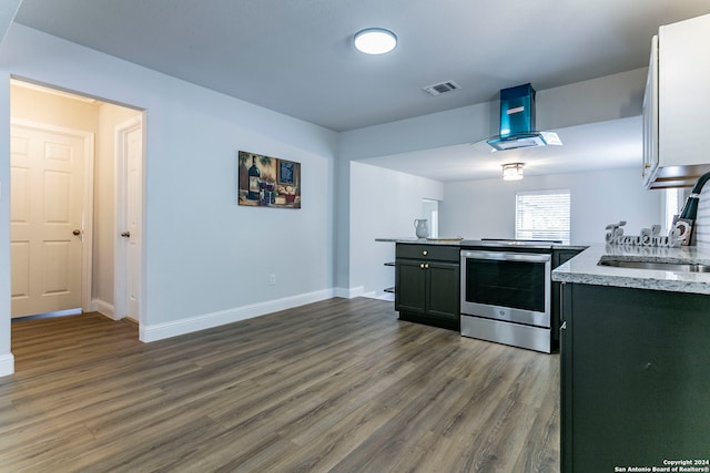 kitchen with stainless steel range, hardwood / wood-style floors, island exhaust hood, sink, and light stone counters