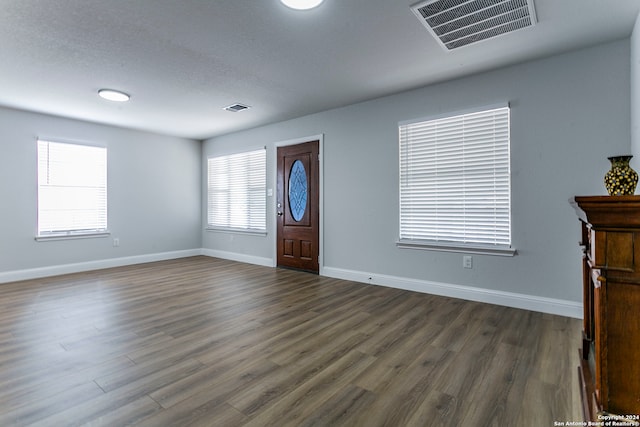 unfurnished bedroom with a textured ceiling, hardwood / wood-style floors, and multiple windows