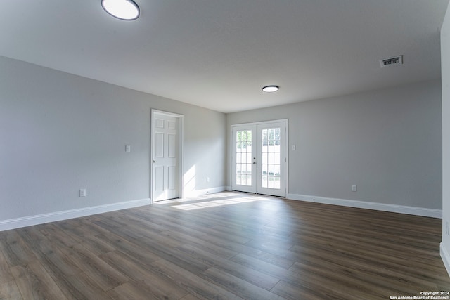 spare room with dark hardwood / wood-style floors and french doors