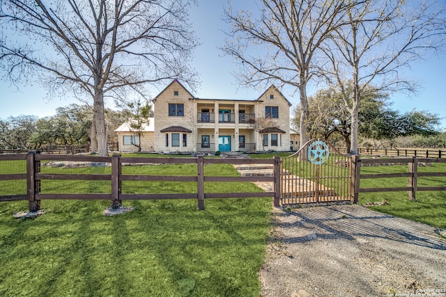 view of front of property with a balcony and a front yard