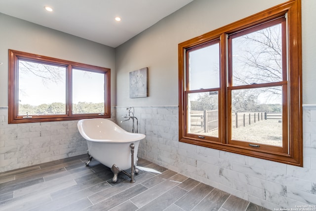 bathroom with a bathtub, plenty of natural light, and hardwood / wood-style floors