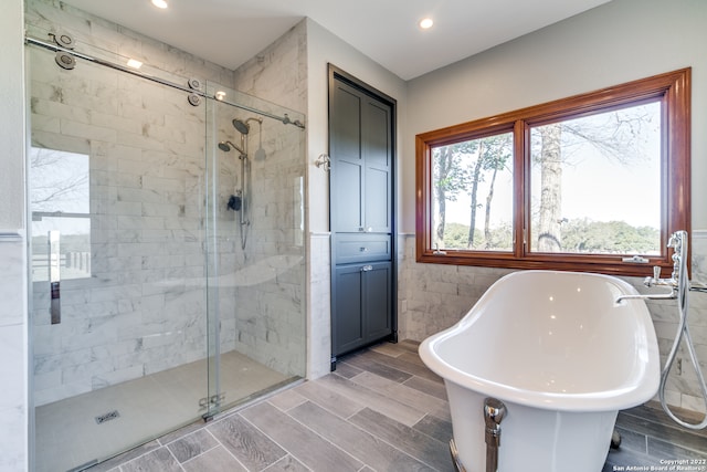 bathroom with tile walls and plus walk in shower