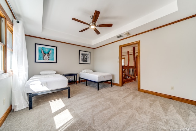 carpeted bedroom with crown molding, a raised ceiling, and ceiling fan