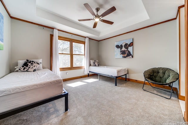 bedroom featuring a tray ceiling, crown molding, light colored carpet, and ceiling fan