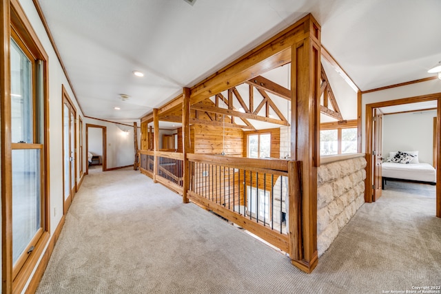 hall with lofted ceiling, carpet, and ornamental molding