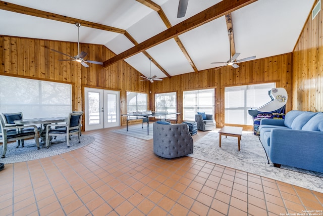 tiled living room with high vaulted ceiling, wooden walls, beam ceiling, and ceiling fan