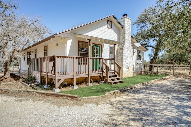 rear view of house featuring a lawn and a deck