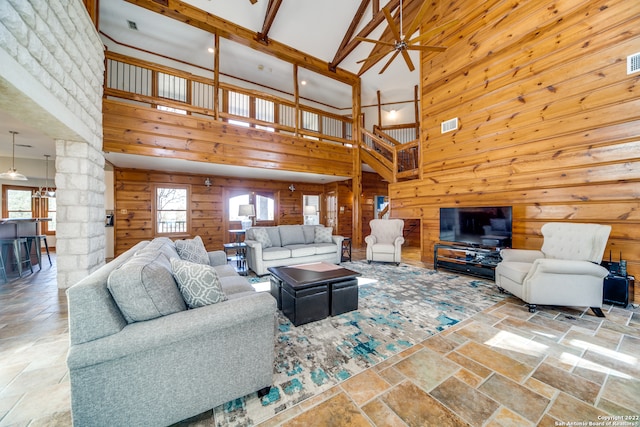 living room with a healthy amount of sunlight, ceiling fan, and high vaulted ceiling