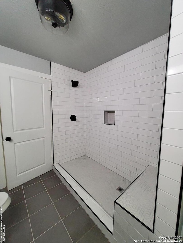 bathroom featuring tile patterned flooring and a tile shower