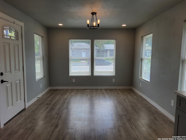 entryway featuring a healthy amount of sunlight, wood-type flooring, and a chandelier