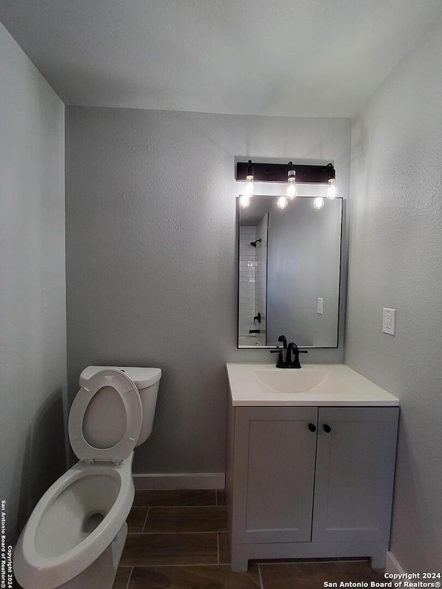 bathroom with vanity, toilet, and wood-type flooring