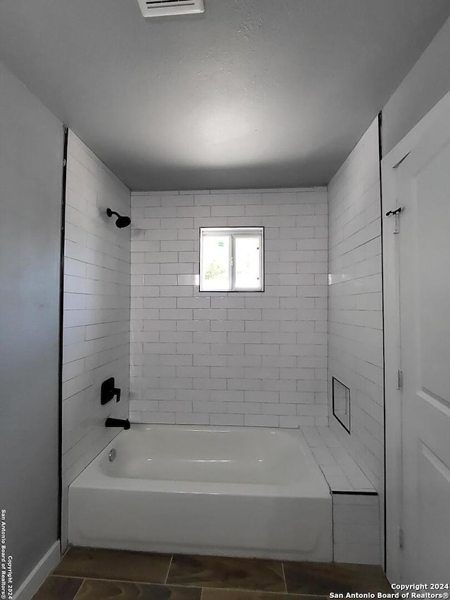 bathroom with tiled shower / bath combo and tile patterned floors