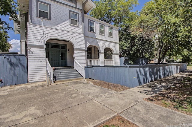 view of front of home featuring a porch and fence