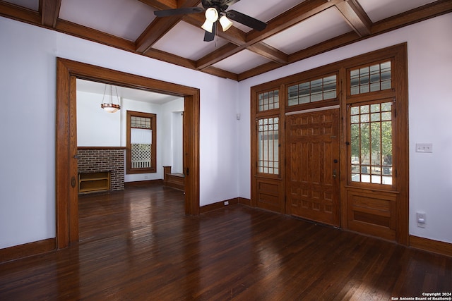 entrance foyer featuring a fireplace, dark hardwood / wood-style flooring, coffered ceiling, ceiling fan, and beam ceiling