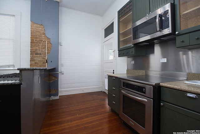 kitchen featuring wood walls, stainless steel appliances, and dark hardwood / wood-style flooring