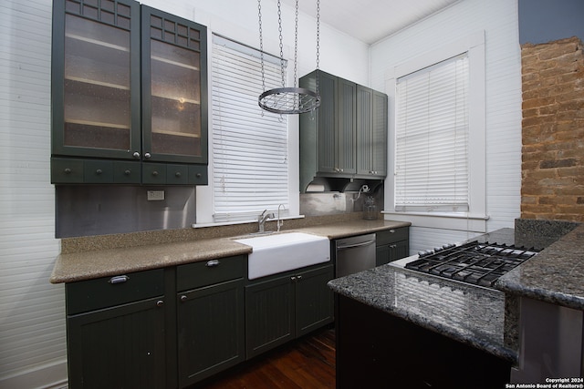 kitchen with appliances with stainless steel finishes, dark hardwood / wood-style flooring, brick wall, sink, and pendant lighting