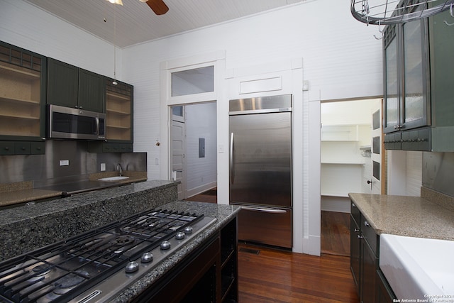 kitchen with appliances with stainless steel finishes, dark hardwood / wood-style floors, and ceiling fan