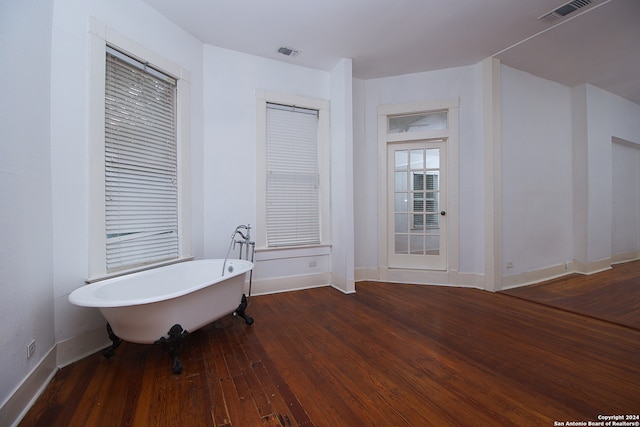 bathroom with hardwood / wood-style flooring and a washtub