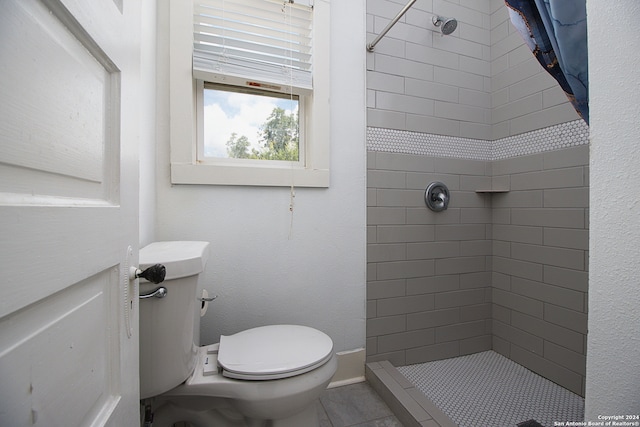 bathroom featuring toilet and a tile shower