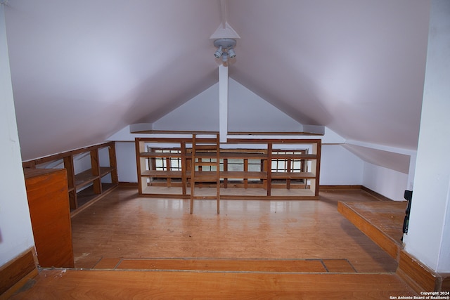 bonus room with lofted ceiling and dark wood-type flooring