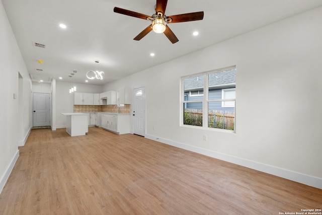 unfurnished living room with ceiling fan, sink, and light hardwood / wood-style flooring