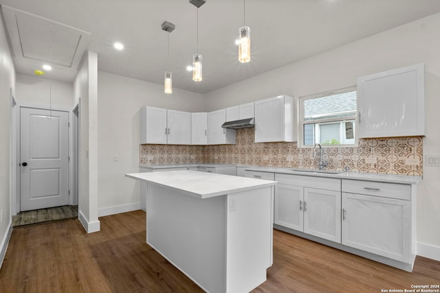 kitchen with hanging light fixtures, a center island, white cabinetry, sink, and wood-type flooring