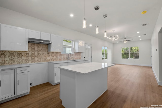 kitchen with decorative light fixtures, ceiling fan, light wood-type flooring, and white cabinetry