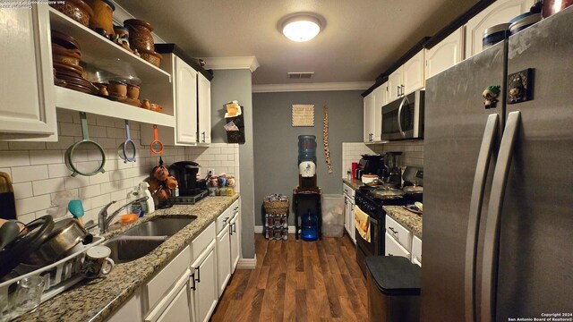 kitchen with light stone countertops, dark hardwood / wood-style flooring, stainless steel appliances, sink, and white cabinetry