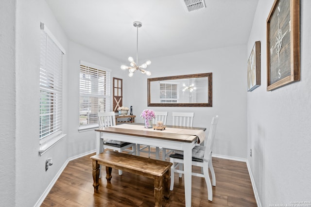 dining room with dark wood-type flooring and a chandelier