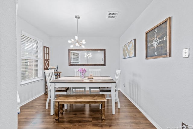 dining room featuring dark wood-type flooring and a notable chandelier