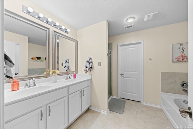 bathroom with vanity, a textured ceiling, tile patterned floors, and shower with separate bathtub