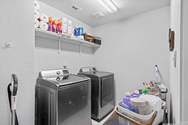 laundry area with a textured ceiling and separate washer and dryer