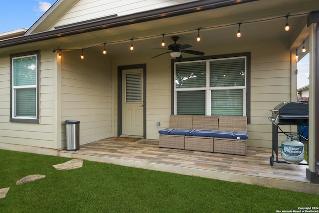 view of exterior entry featuring a yard and ceiling fan