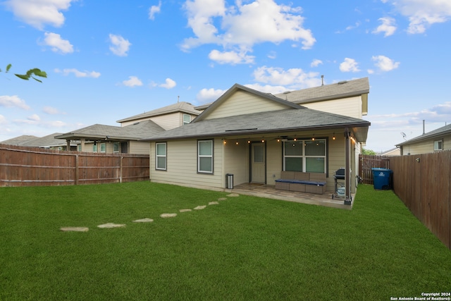 rear view of property featuring a patio area and a yard