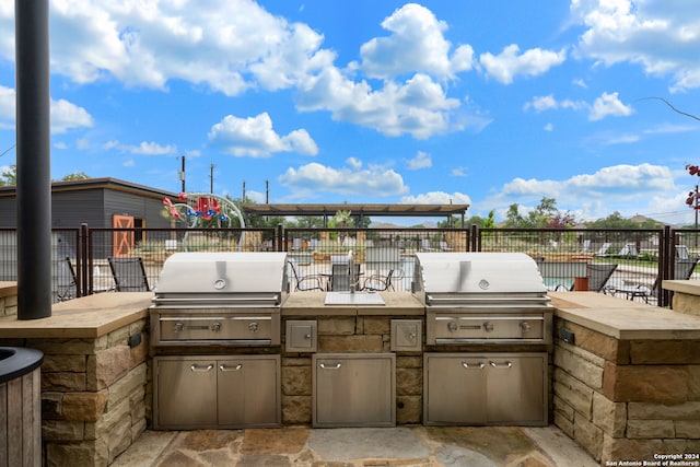 view of patio / terrace featuring exterior kitchen and a grill