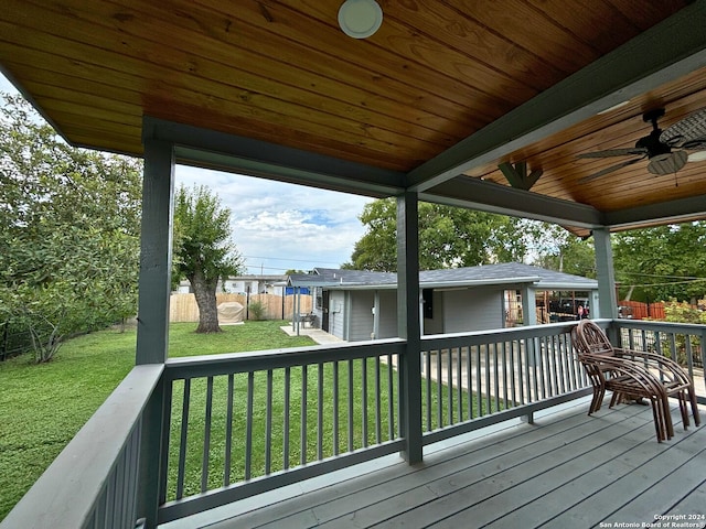 wooden deck with a yard and ceiling fan