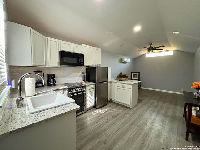 kitchen featuring kitchen peninsula, ceiling fan, appliances with stainless steel finishes, lofted ceiling, and white cabinets