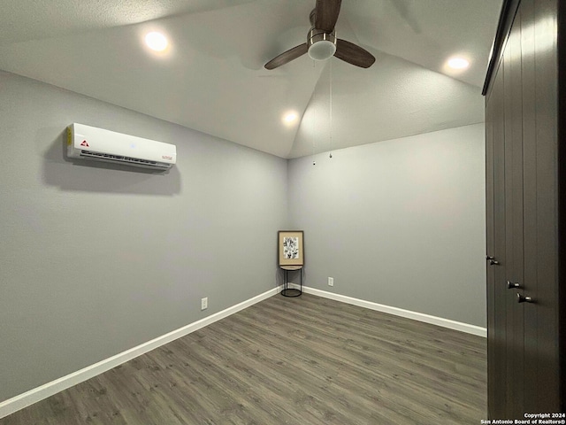 spare room featuring a wall mounted AC, a textured ceiling, dark hardwood / wood-style flooring, ceiling fan, and lofted ceiling