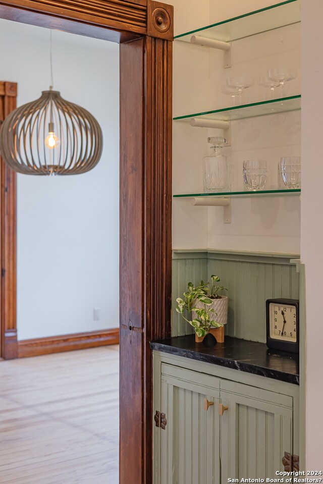 interior details with bar and hardwood / wood-style floors