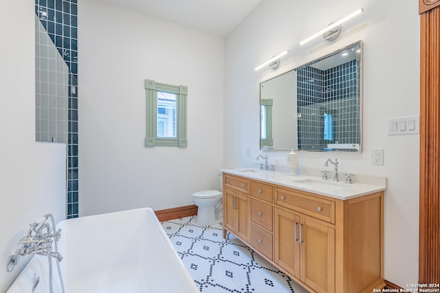 full bath with a freestanding bath, double vanity, a sink, and toilet