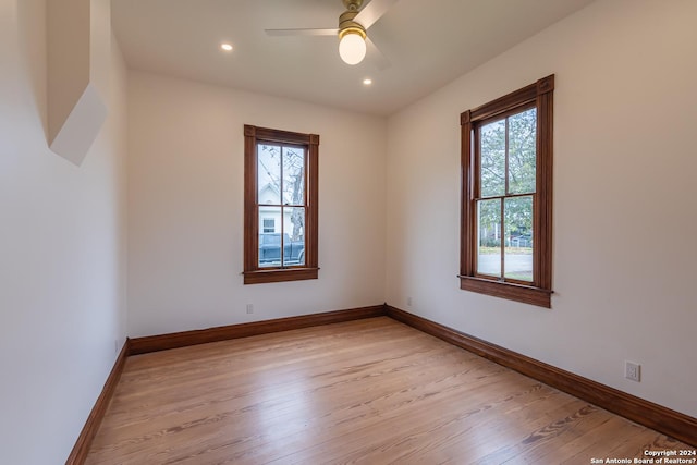 unfurnished room with recessed lighting, plenty of natural light, light wood-style flooring, and baseboards